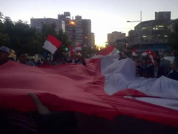 Hinchas de Juventud Unida con una bandera roja y blanca durante los festejos del ascenso